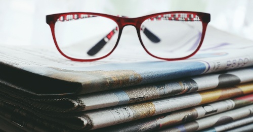 Glasses on newspaper stack