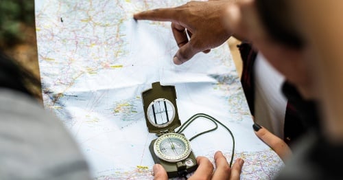 People holding map and compass