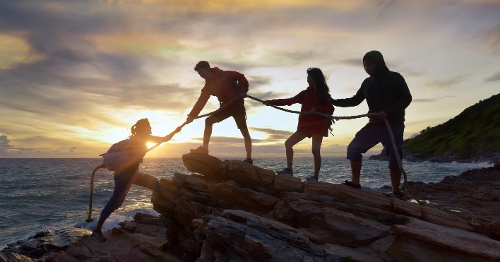 Team climbing mountain together